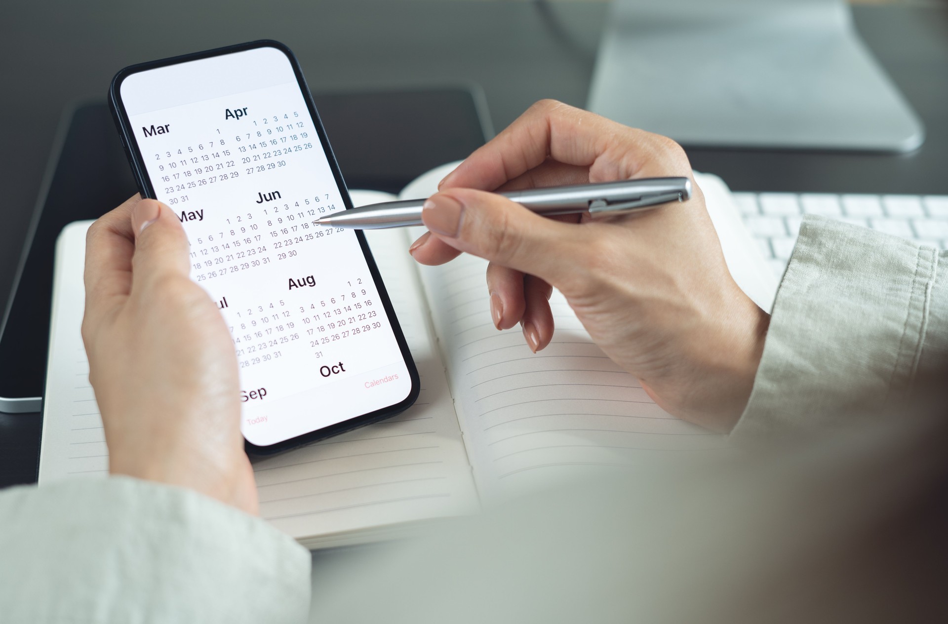 2025 Calendar event planner timetable agenda plan on organize schedule. Business woman using mobile phone with monthly calendar for event planning, Plan scheduling with laptop on office table